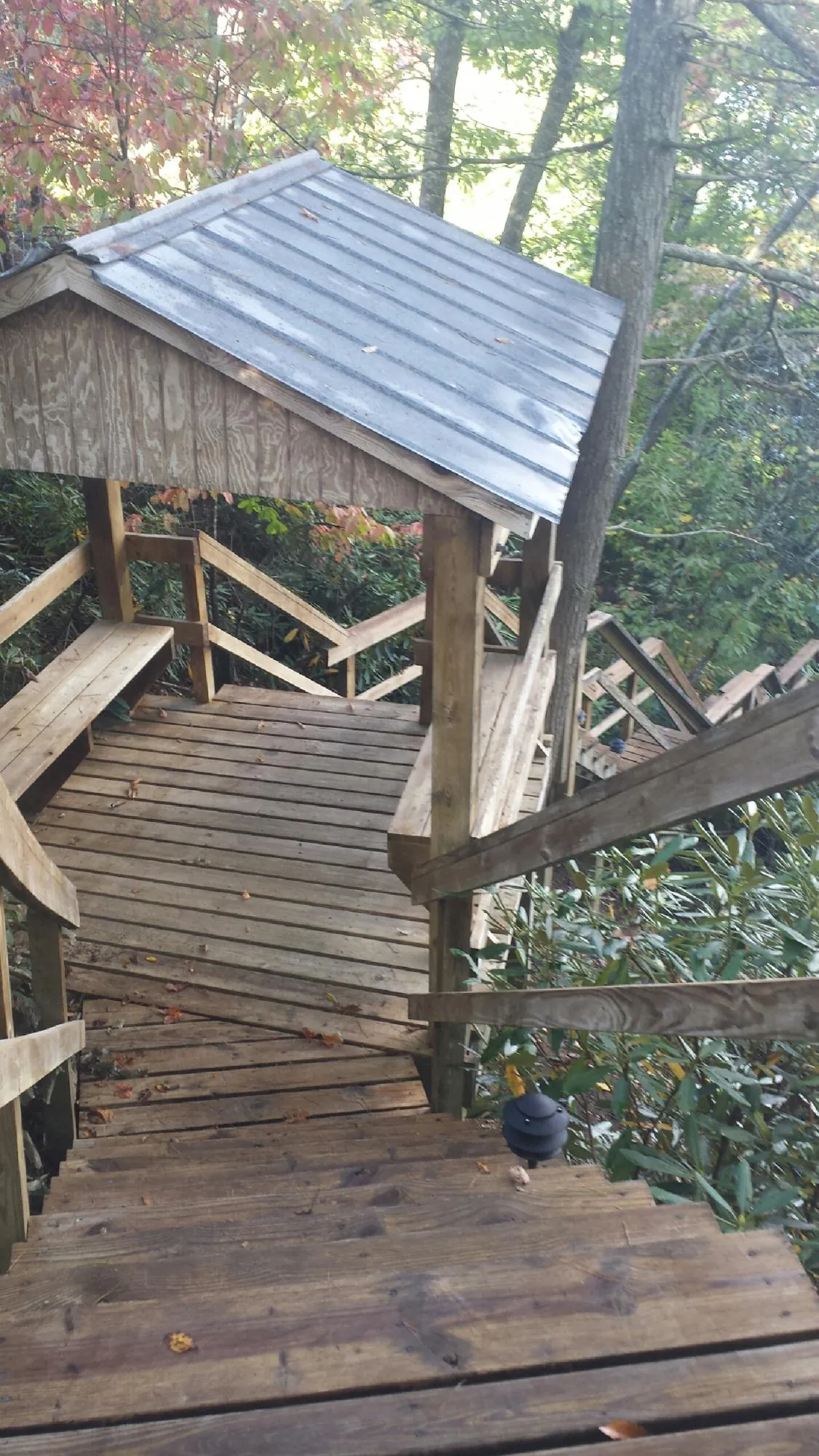 Metal roofed shelter over wooden steps on a wooded walkway — Skylight Repair & Installation work by our crew in Mentor