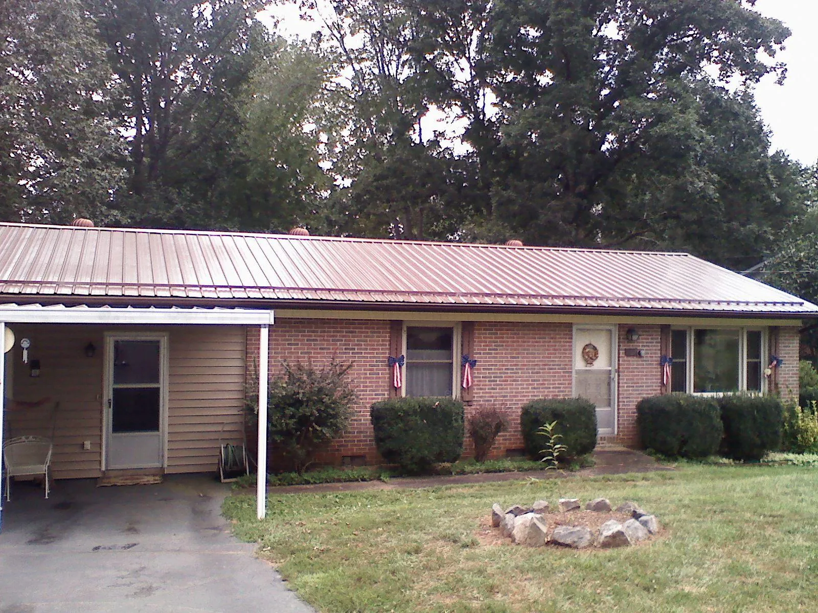 Bronze metal roof and carport on a brick ranch home — Roof Repair work by our crew in Mentor